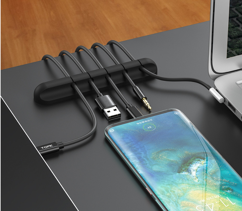 Silikon-Kabelhalter hält fünf Kabel neben einem Smartphone auf dem Schreibtisch